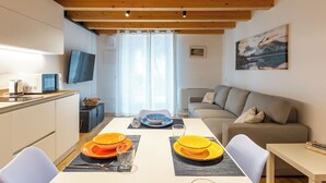 A modern living space with a dining area, kitchen, and seating area. - Nice apartment for 5 guests with A/C, WIFI and patio (Magugnano)