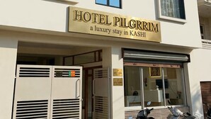 A multi-story building with a sign for 'HOTEL PILGRIM' indicating a luxury stay in KASHI. - Hotel Pilgrrim (Varanasi)