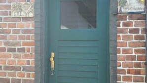 A green door with a small window, a metal doorbell, and a brick wall with a sign that reads 'SEEWOHNUNG'. - Vacation apartment FR1 - "Seewohnung" - Holiday apartment "Seewohnung" with (Graal-Müritz)