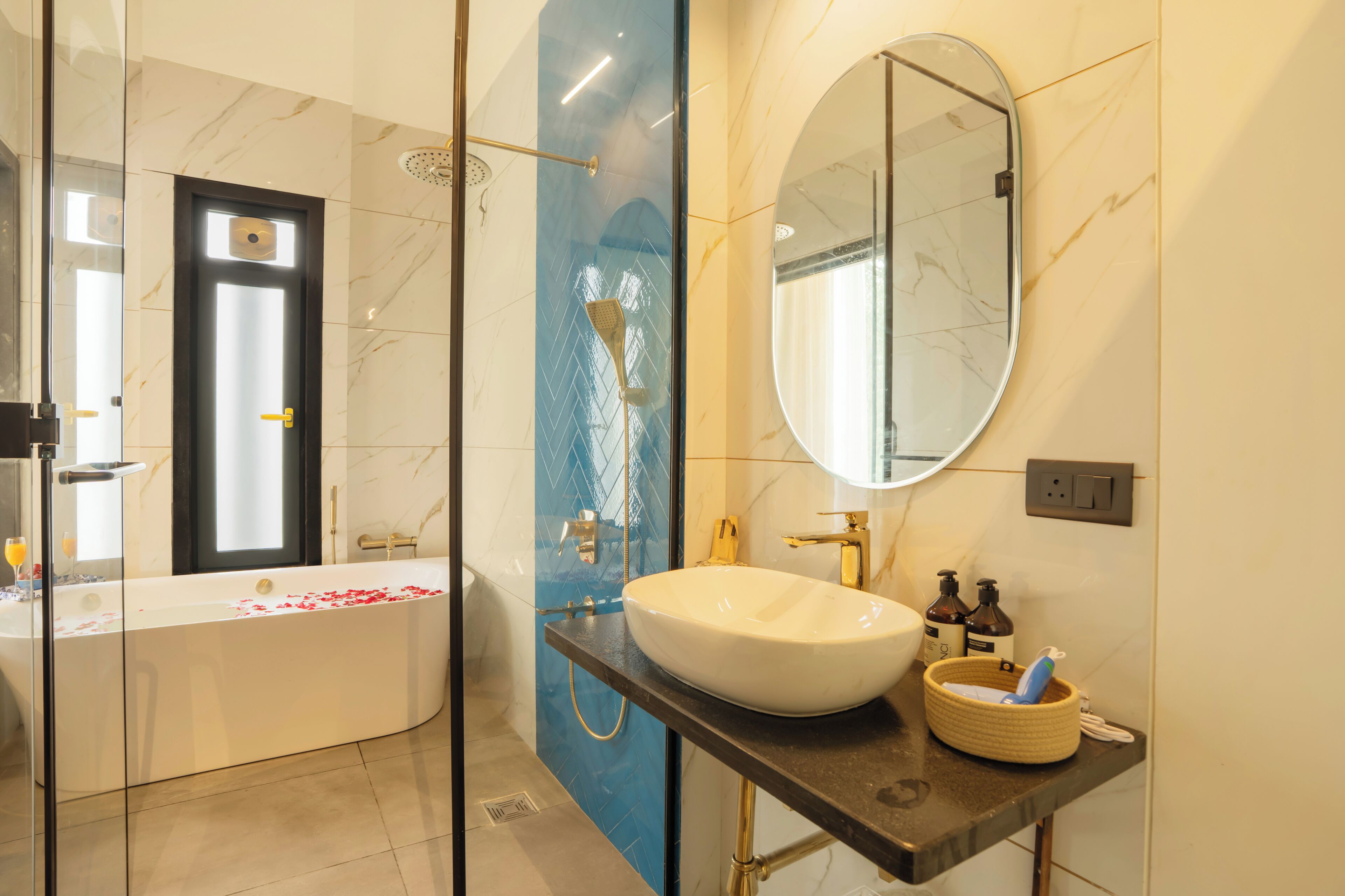 A modern bathroom with a glass-enclosed shower, a freestanding bathtub, a large oval sink, and a mirror above the sink.