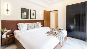 Un dormitorio moderno con una cama grande, mesitas de noche, un armario y un ventilador de techo.