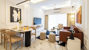 Una sala moderna con comedor, un sofá, una mesa de centro y un televisor.