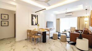 Una sala de estar moderna con comedor, ventilador de techo y televisor de pantalla plana.