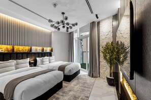 Une chambre d’hôtel moderne avec un grand lit, un luminaire au plafond, une plante en pot et une vue sur l’extérieur.