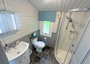 A bathroom with a sink, toilet, shower, and a window with blinds. - 0 bedroom accommodation in Brecon Beacons National Park, (Brecon Beacons National Park,)