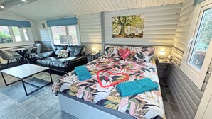 Ein Schlafzimmer mit Bett, Sofa, Schreibtisch und Fenster.