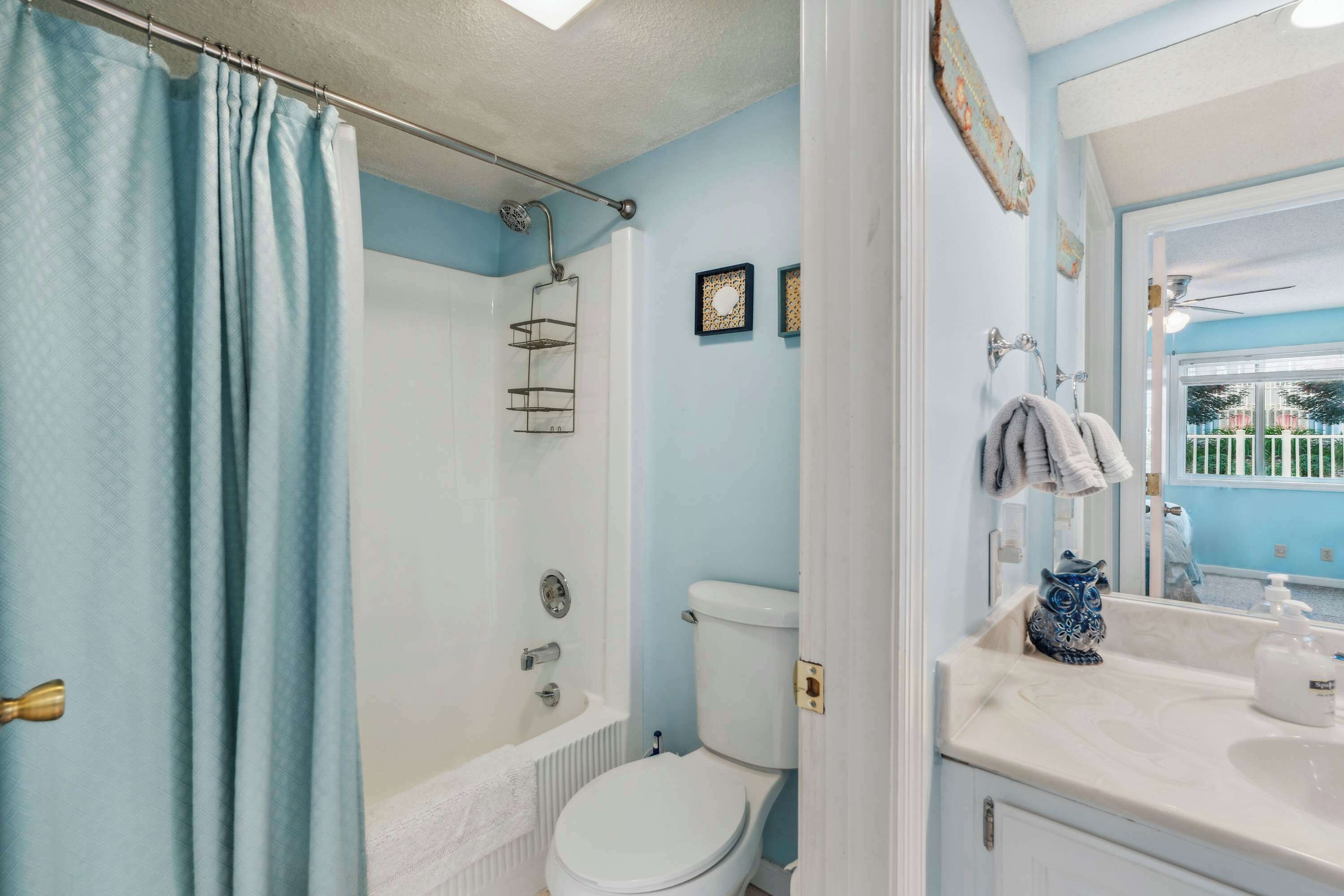 A bathroom with a bathtub, toilet, and sink.