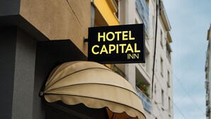 Et hotelskilt med navnet "HOTEL CAPITAL INN" og en dekorativ markise.