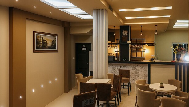 En moderne hotellobby med en central søjle, siddeområde og bar.
