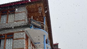 Un edifici de diversos pisos amb un rètol que diu 'Welcome to Café Kush'.