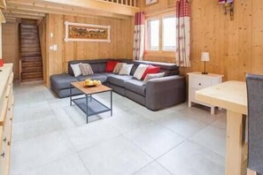 Un interior de madera con un sofá, una mesita y un armario.