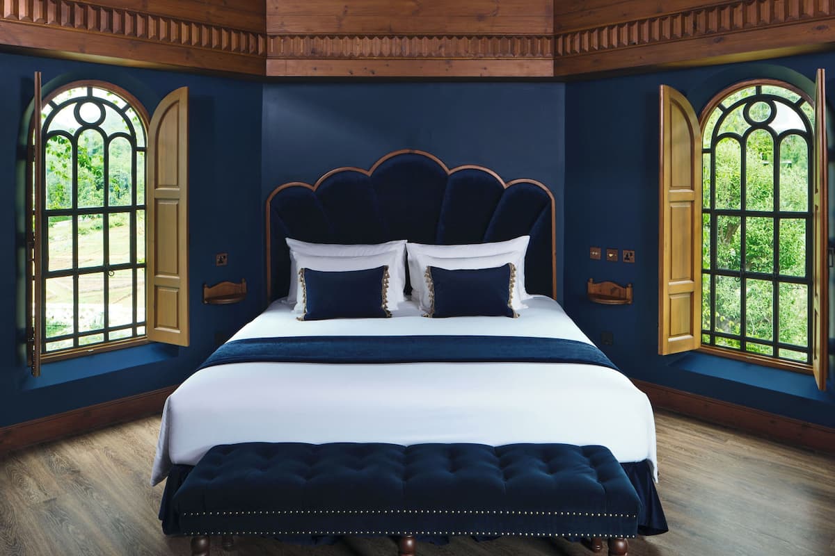 Quarto com cama, duas janelas e design de teto com estrelas.