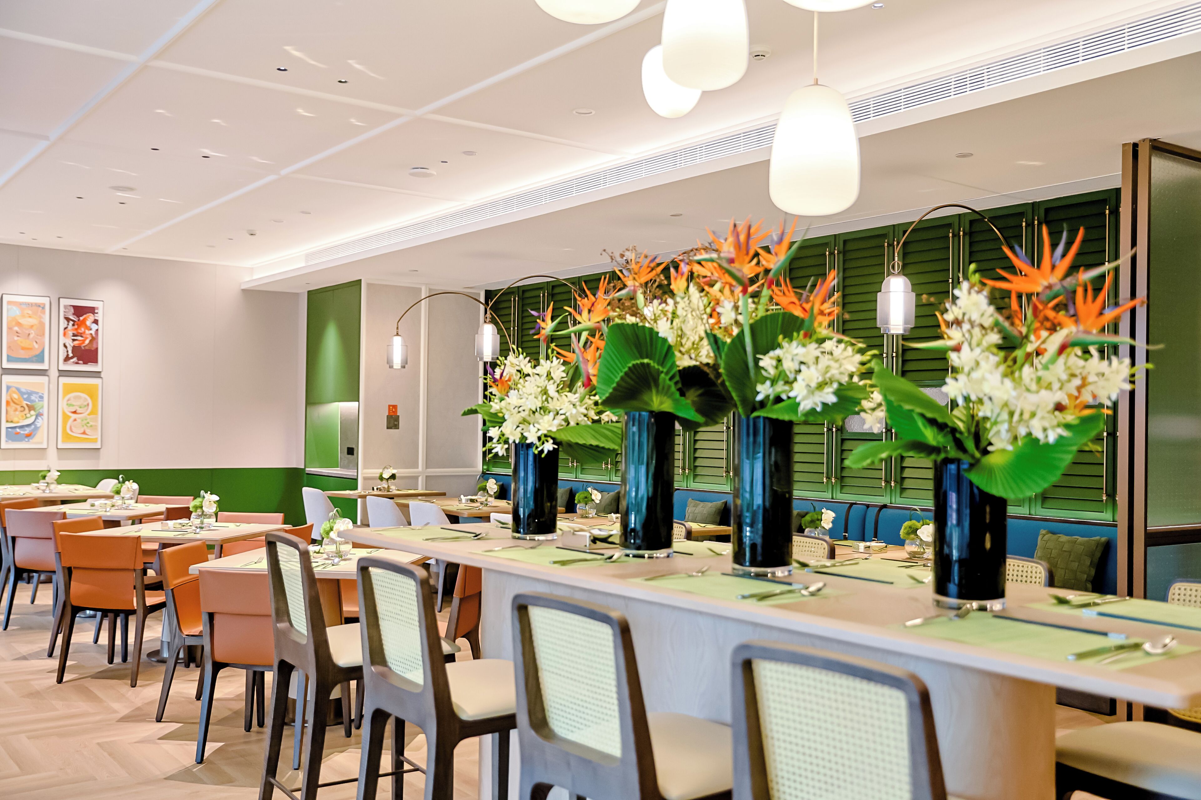 Un comedor moderno con mesas, sillas y jarrones decorativos.