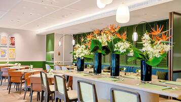 Un comedor moderno con mesas, sillas y jarrones decorativos.