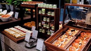 A buffet with various food items, including pastries and desserts, displayed on wooden stands and trays.