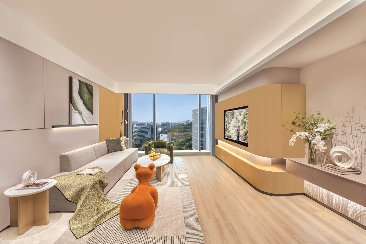 A modern living room with a sofa, a coffee table, a bear-shaped chair, and a TV.