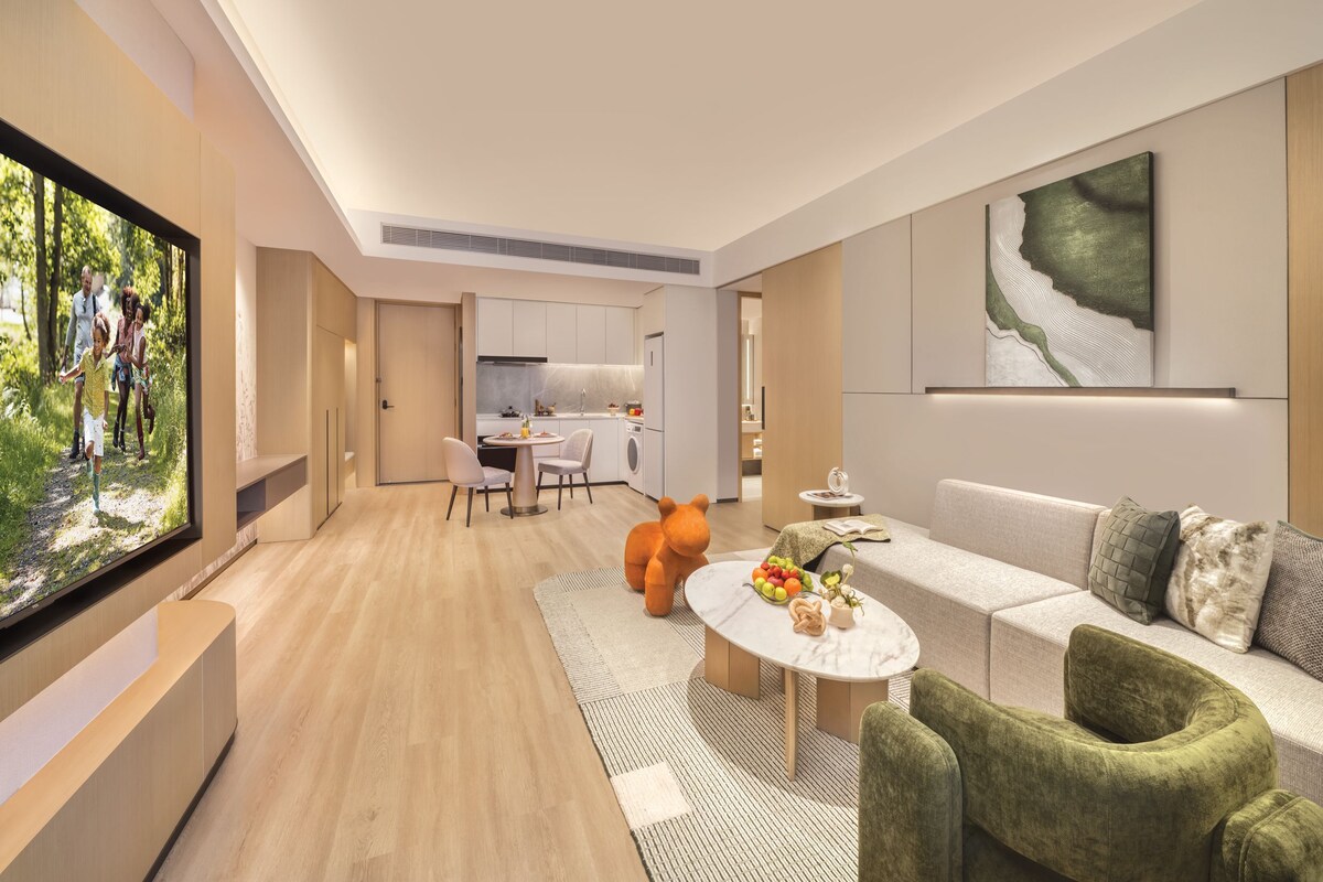 A modern living room with a sofa, a coffee table, and a television.