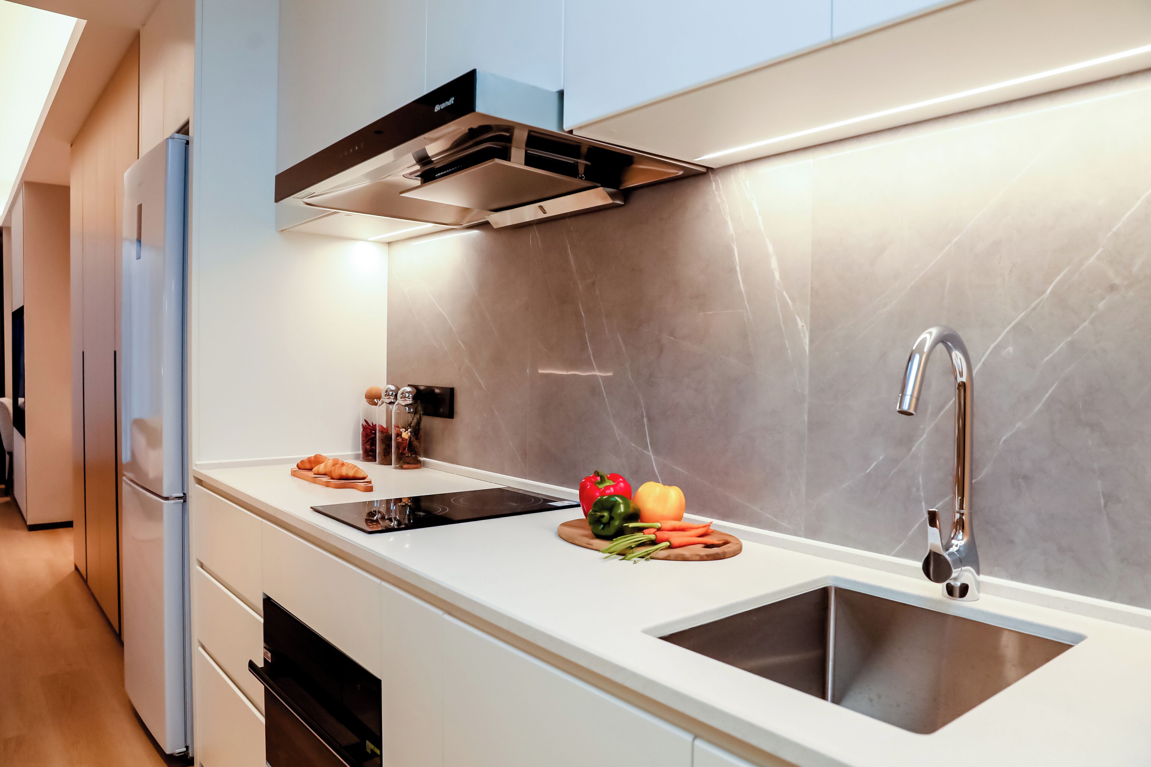 Una cocina moderna con un lavamanos doble, electrodomésticos de acero inoxidable y un salpicadero de mármol.