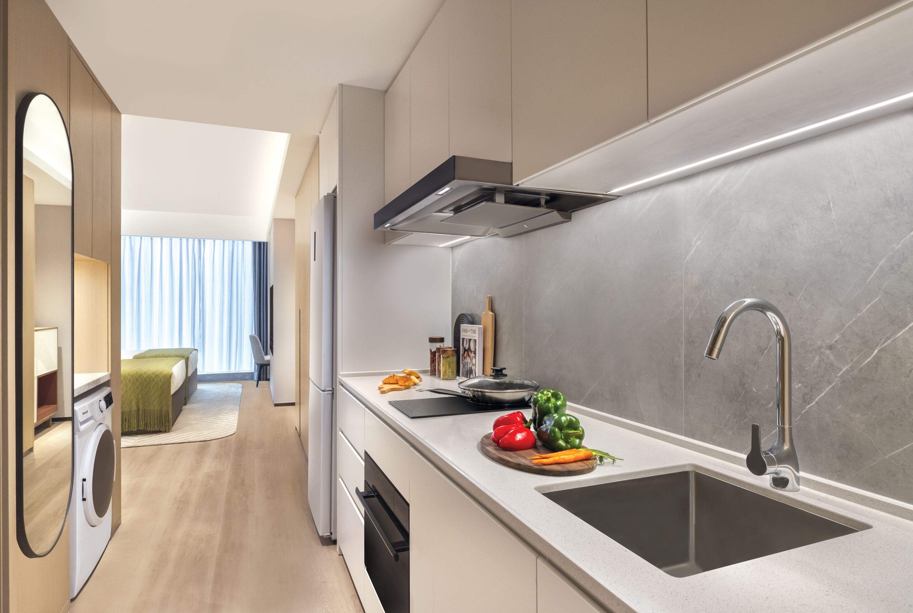A modern kitchen with a built-in dishwasher, a large sink, and a window with curtains.