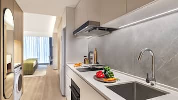 Una cucina moderna con lavastoviglie integrata, un lavello capiente e una finestra con tende.