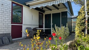 Et hus med en veranda, et bord og stole.