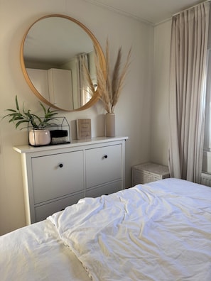 A bedroom with a bed, a dresser, a mirror, and a potted plant. - Chalet 229 (4 persons) (Petten)