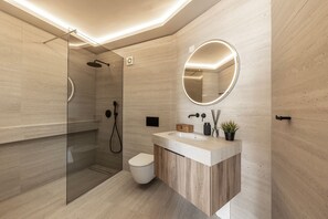 Ein modernes Badezimmer mit Duschkabine aus Glas, Toilette und Waschtisch mit Spiegel.