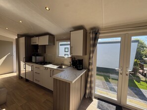 A modern kitchen with a large window, a built-in microwave, and a sink. - J 041 New chalet! (more photos to follow) (Petten)