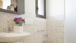 Un baño con lavabo, inodoro y espejo.