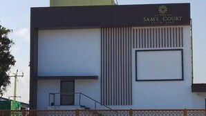 A building with a sign reading 'Sam's Court Hotel.' - Sam's Court Elite Stay (Manachanallur)