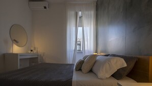 A modern bedroom with a bed, bedside table, and a window with curtains. - Baronio@home - One Bedroom Apartment, Sleeps 4 (Rome)