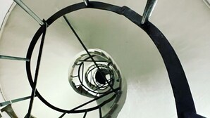 A spiral staircase with metal railings and a white wall. - Santonofrio Colors - Three Bedroom Apartment, Sleeps 8 (Rome)
