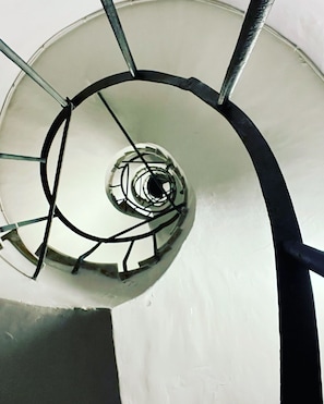 A spiral staircase with metal railings and a white wall. - Santonofrio Colors - Three Bedroom Apartment, Sleeps 8 (Rome)