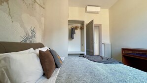 Un dormitorio con cama, armario y radiador.