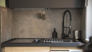 A kitchen with a black countertop, stainless steel sink, and a black faucet. - Vatican Boutique Apartment St. Peter Dome View (Rome)