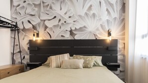 A bedroom with a modern bed, a headboard with built-in lighting, and a decorative wall panel. - Vatican Boutique Apartment St. Peter Dome View (Rome)