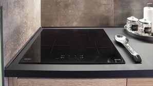 A kitchen with a black induction cooktop, a spoon, and salt and sugar containers on the counter. - Vatican Boutique Apartment with Large Terrace (Rome)