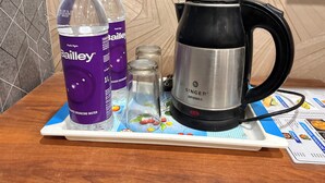 A tray with two Bailey branded water bottles, a Singer aroma kettle, and a small glass container with a spoon. - Hotel RAJ (Haridwar)