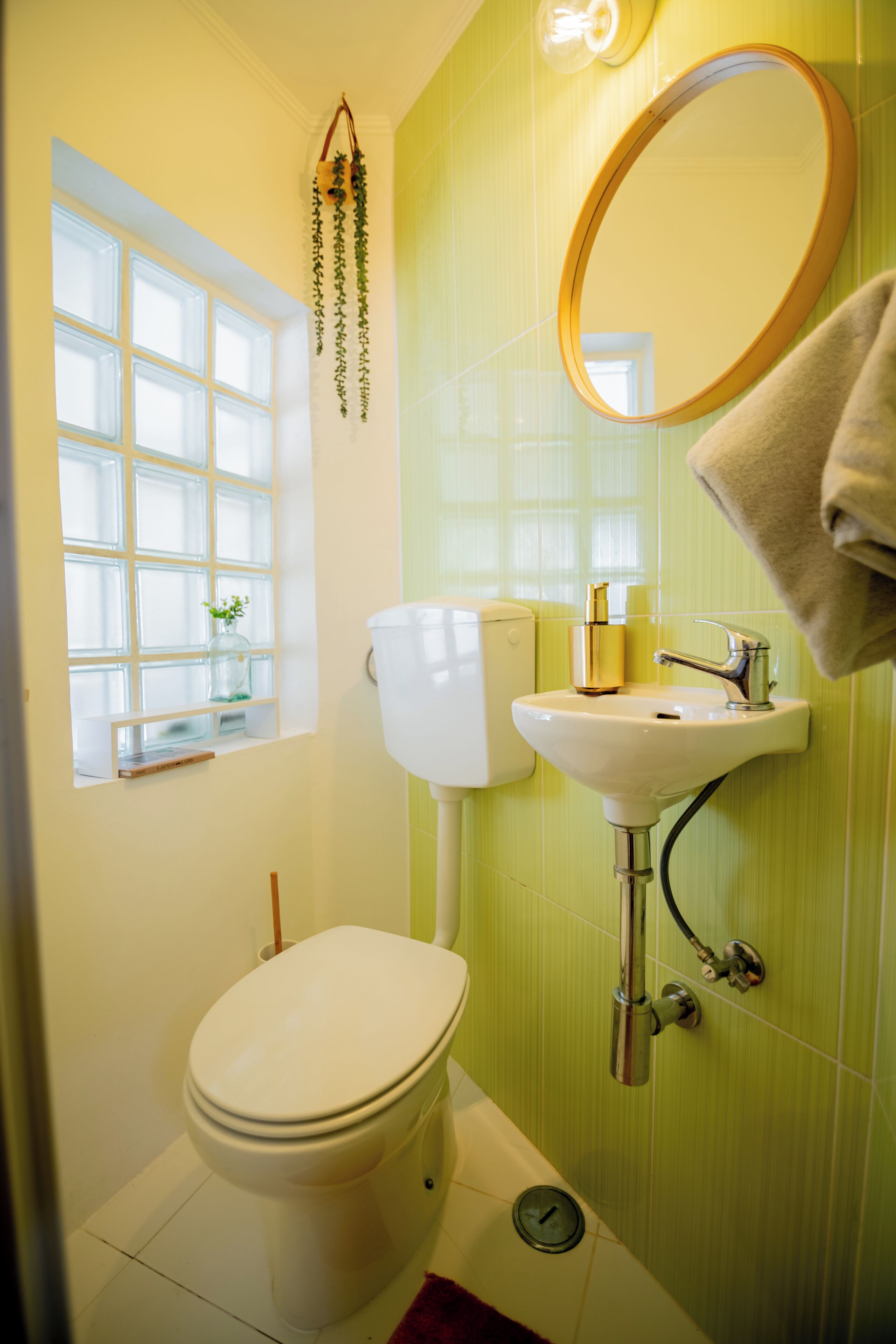 Een badkamer met toilet, wastafel, spiegel en raam.