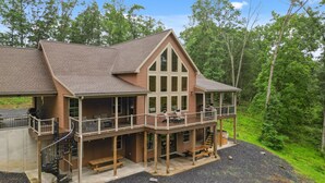 A two-story log cabin with a balcony, outdoor seating, and a fireplace. - Fernwood Lodge - 15 Min To Raystown Lake (Huntingdon)