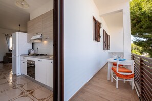 A modern kitchen with a refrigerator, stove, and oven. There is a dining area with a table and chairs. - Holiday Home 'Vacanza Alle 4 Colonne - 1' with Balcony, Wi-Fi and Air Conditioning (Santa Maria al Bagno)