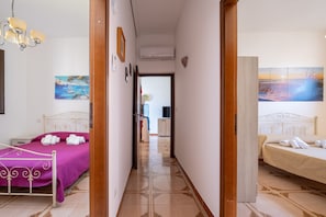 Una habitación de hotel con cama, baño y un pasillo que conduce a otra habitación.