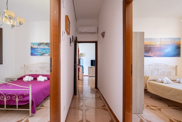 A hotel room with a bed, a bathroom, and a hallway leading to another room. - Holiday Home 'Vacanza Alle 4 Colonne - 1' with Balcony, Wi-Fi and Air Conditioning (Santa Maria al Bagno)