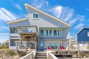A two-story beach house with a balcony, deck chairs, and a clear view of the ocean. - Time in a Bottle Oceanfront, Spacious 6 bedroom in Surf City! (Surf City)