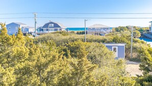Una zona residencial costera con casas, un pequeño muelle y una vista despejada del océano.