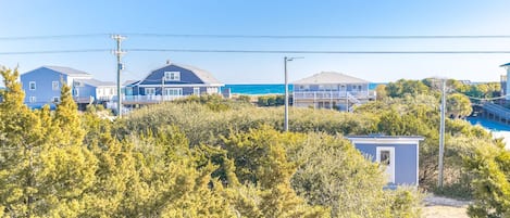 Un quartier résidentiel situé sur la côte, avec des maisons, une plage et une végétation luxuriante.