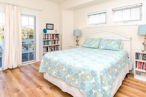 A bedroom with a bed, a bookshelf, a window, and a door. - Time Out Cozy 4-bedroom beach house in Topsail Beach, perfect for family (Topsail Beach)