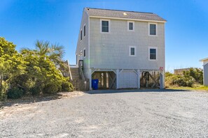 A two-story building with a covered entrance and a gravel driveway. - Whittington - Oceanfront 3-Bedroom, perfect for family getaways! (North Topsail Beach)