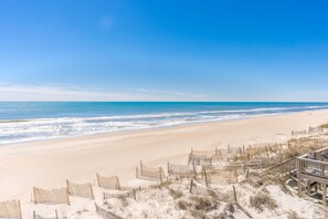 A beach with a wooden fence and beach chairs, overlooking the ocean. - Whittington - Oceanfront 3-Bedroom, perfect for family getaways! (North Topsail Beach)