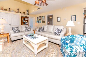 A living room with a sofa, coffee table, and patterned rug. - Whittington - Oceanfront 3-Bedroom, perfect for family getaways! (North Topsail Beach)